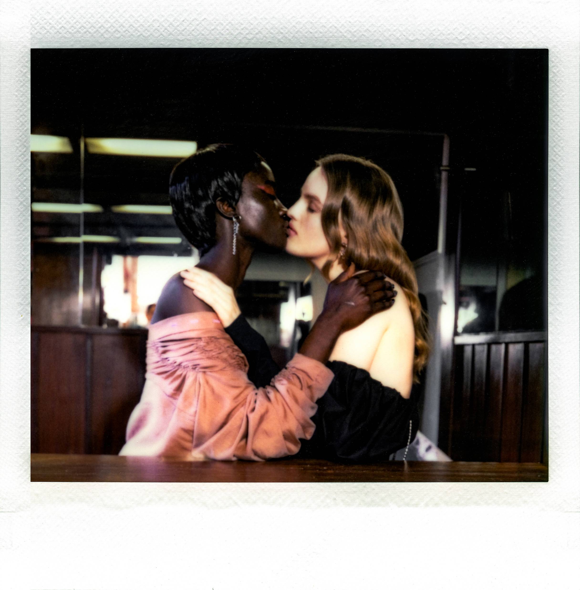 Photographie instantanée de deux femmes qui s’embrassent